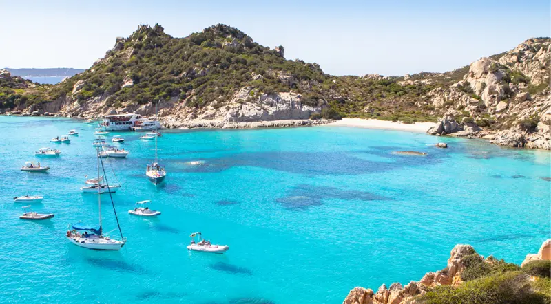Boats moored off Cala Corsara on Spargi island, La Maddalena